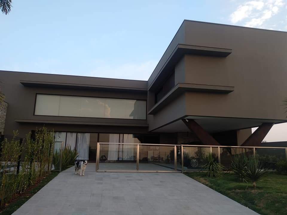 Casa contemporânea com fachada em alumínio e amplos vãos envidraçados