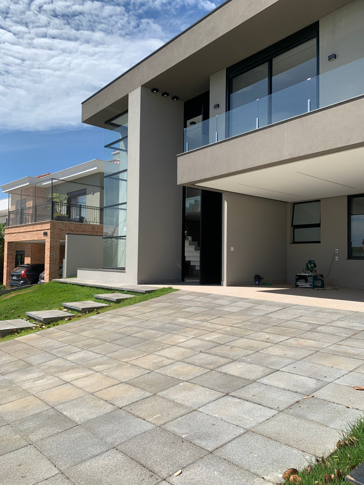 Fachada moderna com porta pivotante e guarda-corpo de vidro