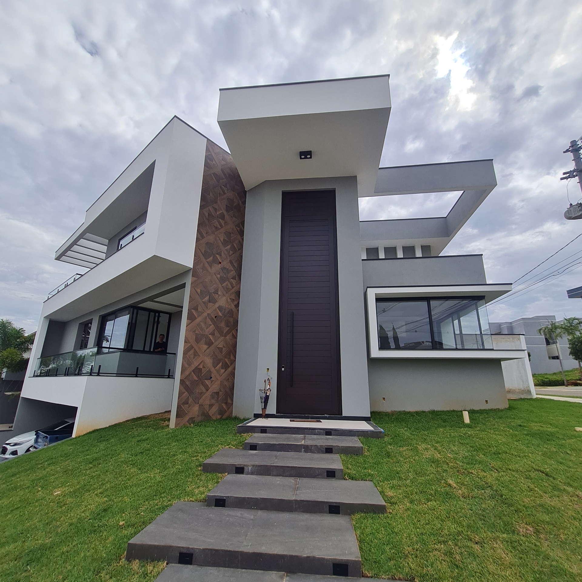 Casa de alto padrão com porta pivotante e amplas esquadrias